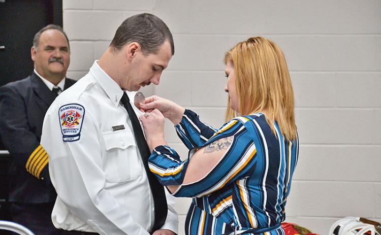 Lt. Joseph Deal has his EMS badge pinned on by fiancee Monica Dean during a ceremony Friday in Clarkesville.