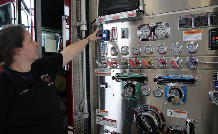 Cornelia firefighter Erin Higgins points out the foam gauge on the engine. Several local departments already use environmentally friendly foam.