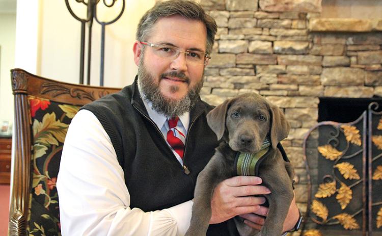 Hillside Memorial Chapel and Gardens owner Brent Tolbert hold Shiloh, the newest addition to their workforce.