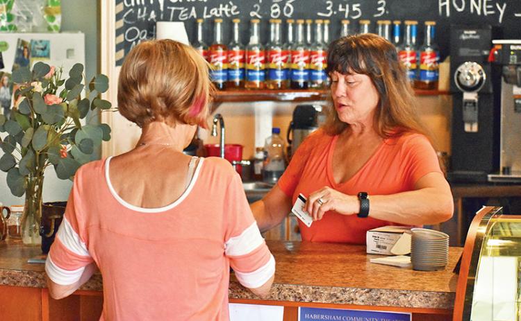 Angie Guthrie, owner of Java Joe’s Coffee Shop in Clarkesville, sells a gift card to Sheila Humphrey on Saturday. Photo by CODY ROGERS/Staff