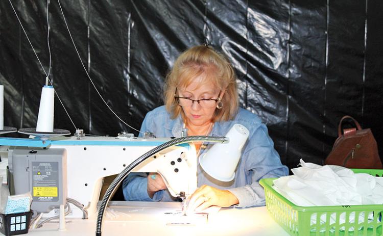 Cathy LaPrade works on a protective mask at My Pool Pal in Alto.