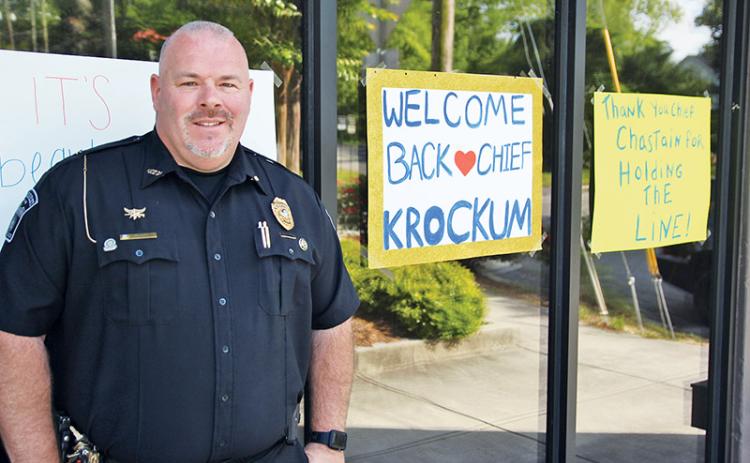 Demorest Police Chief Robin Krockum stands outside his department with signs showing community support.