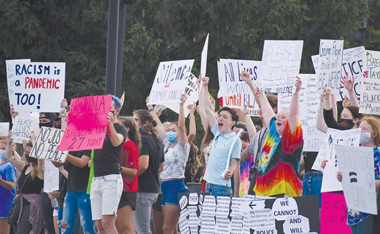 Demonstrators made their voices heard through signs, chants and songs Friday night in Clarkesville as they spoke out against racism. Photo by CODY ROGERS