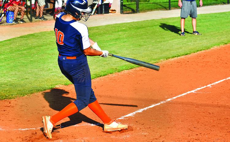 Kyla Quiles follows through on a single up the middle to drive in the game-tying run in the bottom of the seventh. Quiles also pitched five innings in relief and struck out seven Lady Indians. Below, Sadie Hawkins tracks a fly ball in Tuesday’s game against Stephens County.
