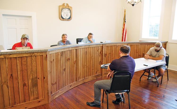 Mt. Airy Council members Adam Tullis, Ray McAllister and Mayor Pro-Tem Mike McCoy discuss the town millage rate Wednesday night. Seated below are councilmen Patrick Leford and Chris Green.