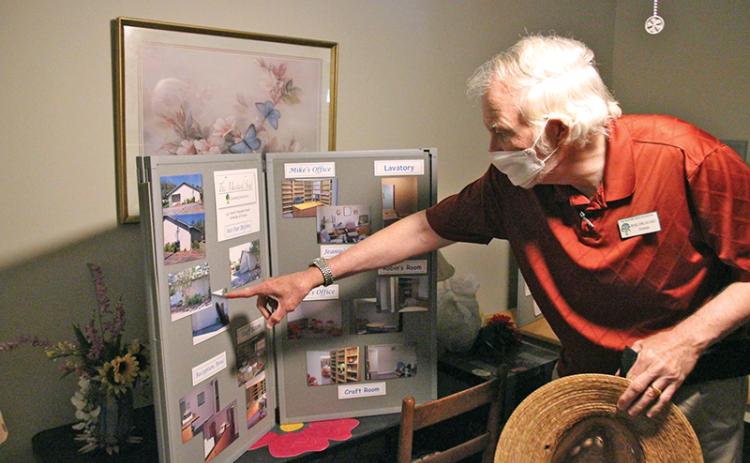 The Mustard Seed Director Michael Johns points to a collage of pictures from when their Cornelia office was purchased.