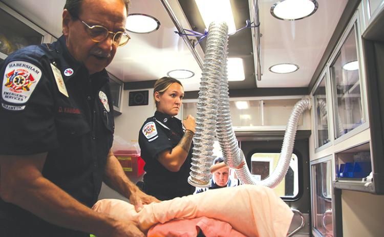 Habersham Emeregency Services Paramedic Dave Kinnunen, advanced EMT Courtney Fortner and critical care paramedic Scott Boleman give a tour of one of their ambulances. Kinnunen shows one of the hoses they use for COVID-19 patients to breathe into.