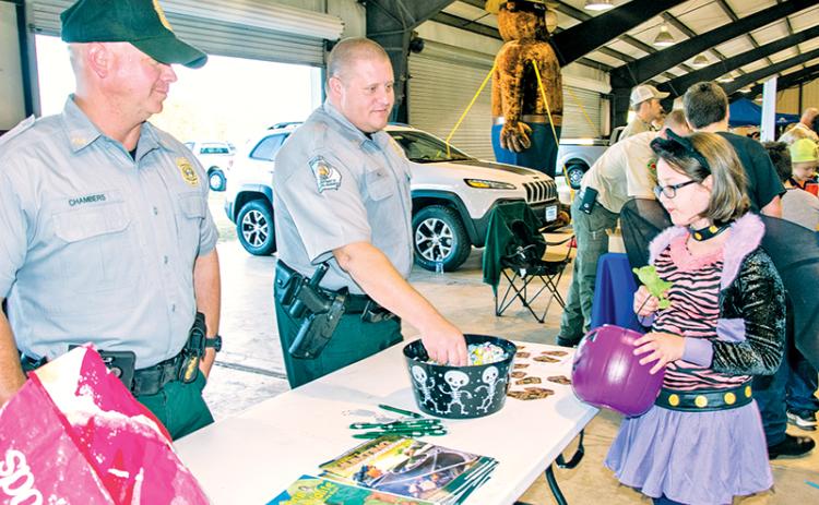 Georgia Department of Natural Resources officers Chad Chambers (left) and Joe Hill offer candy to a cool cat at last year’s E-911 Halloween event in Habersham County. The event has been cancelled for this year due to lingering COVID-19 concerns.
