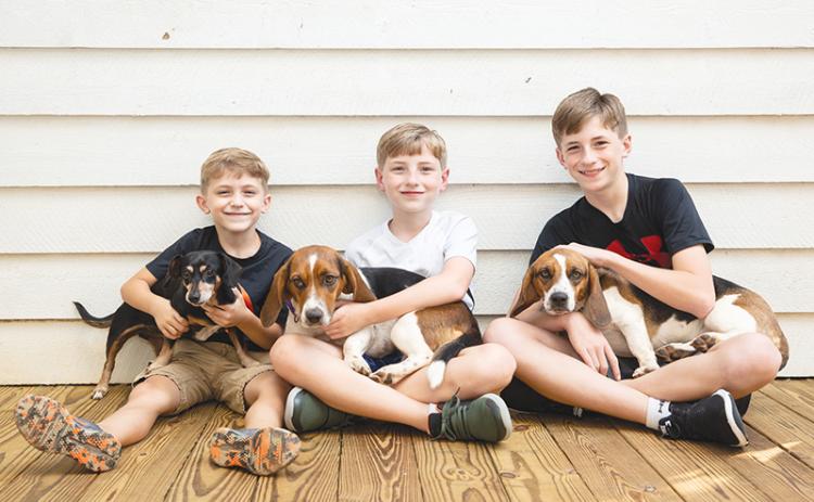 Jase, Reilly and T.J. Cox each hold one of the family’s beloved pets. Seargent (left) returned home soon after escaping, but Rosie was lost for nearly five days, while Amelia was found after being missing for six days.