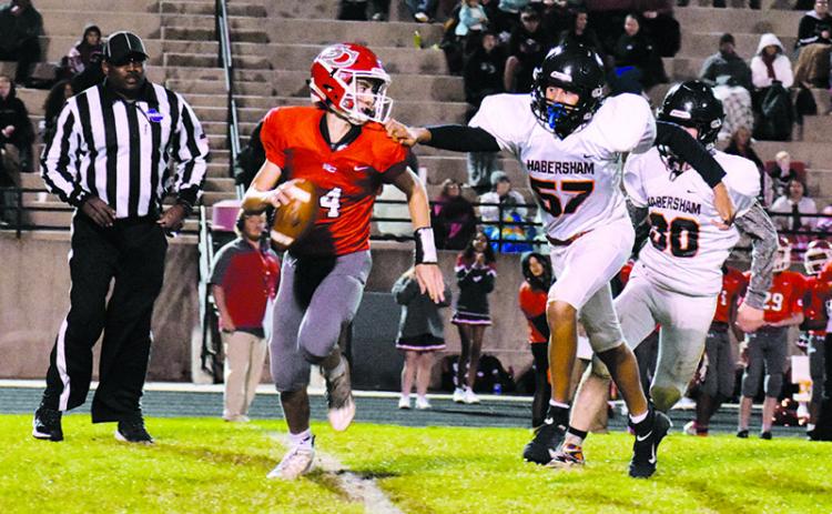 Judge Wilbanks (57) pressures Indians' quarterback Tripp Underwood (14) on one of his only pass attempts of the night to keep the game knotted at 14-14 going into halftime. ISAIAH SMITH/Staff
