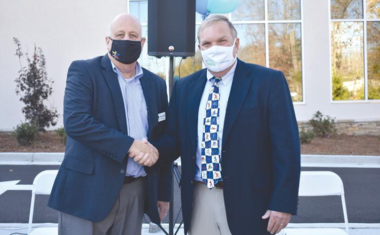 Dr. F. Stuart Sanders (right) is congratulated by Habersham County Chamber of Commerce Chairman Sidney Roland III after a legacy wall was erected in his honor Tuesday at the new Rehabilitation & Orthopedics Complex at Habersham Medical Center. CHAMIAN CRUZ/Staff