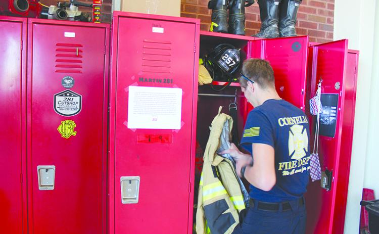 Cornelia firefighter Tristan Stephens goes through his locker during a recent shift. WoodmenLife’s fundraiser is set up to help the Cornelia Fire Department purchase a new emergency life raft and other equipment to be used for training in its new fire station.