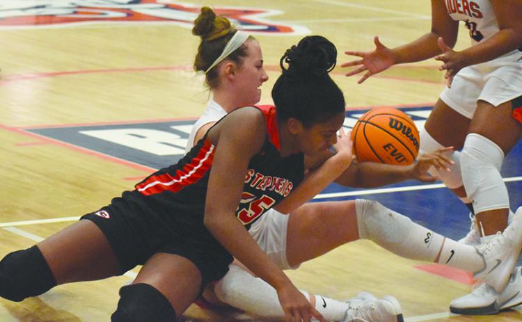 Habersham Central’s Taylor Wade battles Stephens County’s Ranjah Verdell for a loose ball during Friday night’s game.