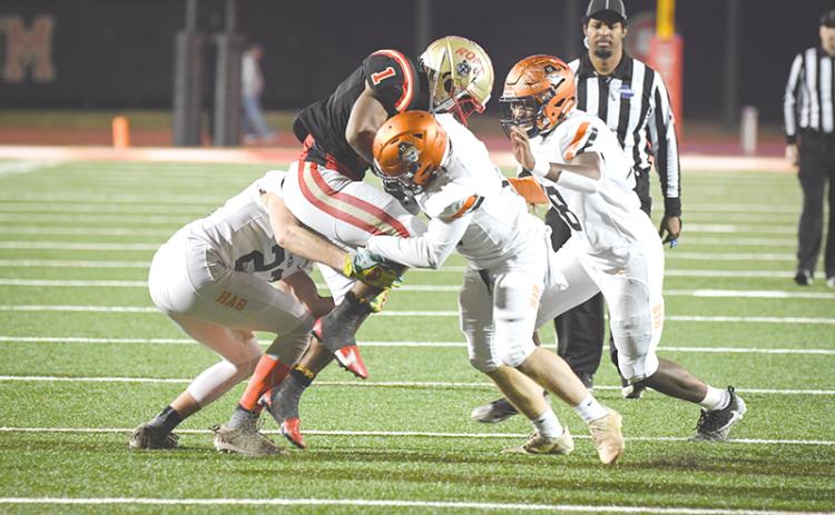 Habersham Central tacklers (from left) Grayson Taylor, Patrick Tedder and Alex Aaron  converge on Rome’s EJ Lackey during Friday’s playoff game. TOM ASKEW/Special