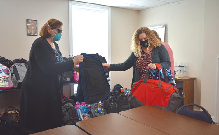 Renee Smagur, 4-H program assistant, organizes backpacks with Habersham DFCS County Director Cara Galloway.