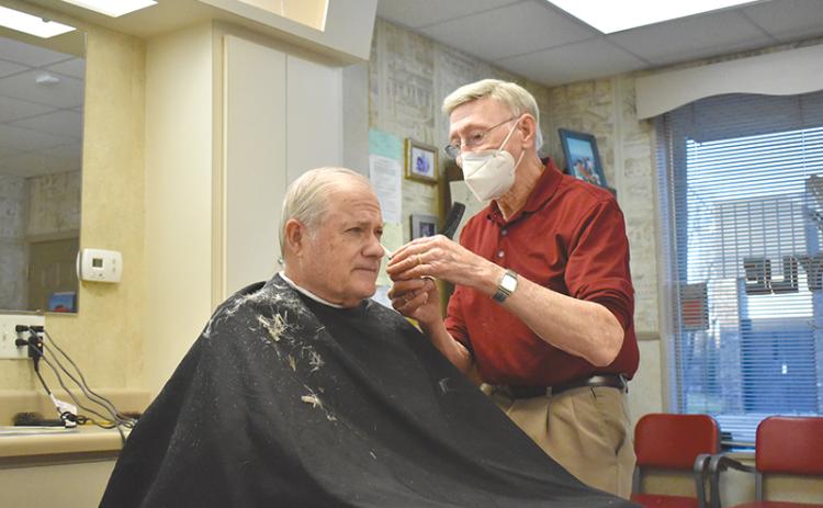 Jim Daniel works on a haircut Thursday morning for one of his longtime customers, Arthur Howard. Daniel has cut hair at his shop in Cornelia since 1961.