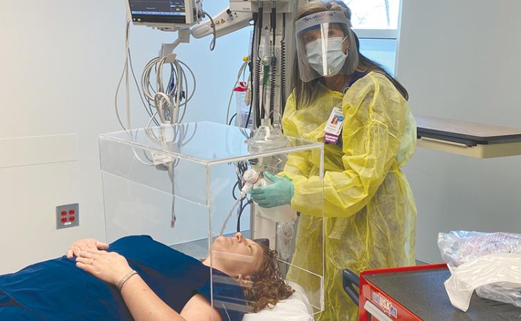 Jamie  Mentzer uses an  intubation box and practices placing a breathing tube into a COVID-19  patient that is unable to breathe on their own. HABERSHAM MEDICAL CENTER/Submitted