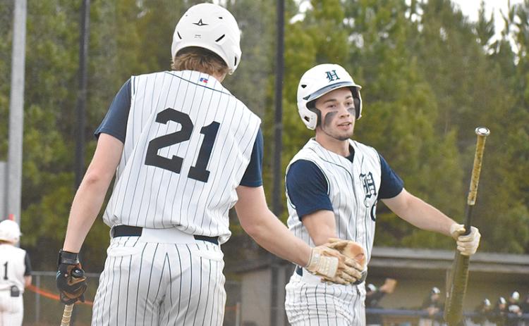 Logan Bogue congratulates Azzi Cervantes after scoring one of the Raiders’ five runs in the second inning of Wednesday’s game against the Franklin County Lions.