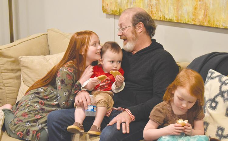 Randy Chester shares a smile with daughter Paloma as little guy Rune samples the cookies and Azalea checks out a cupcake to celebrate their new space.