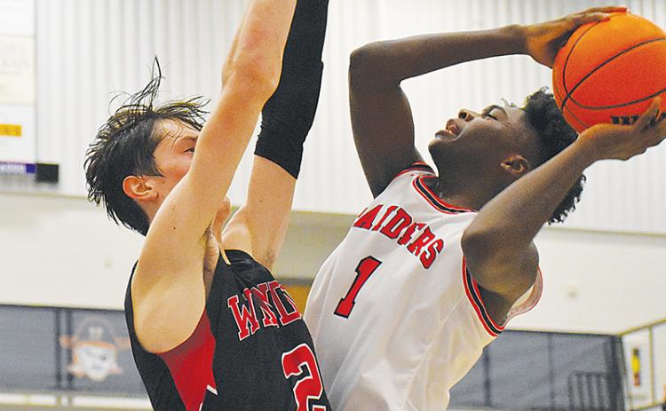 Habersham Central’s Bryce Pittman (right) goes up for a shot with a Winder-Barrow defender draped all over him during Tuesday’s game.