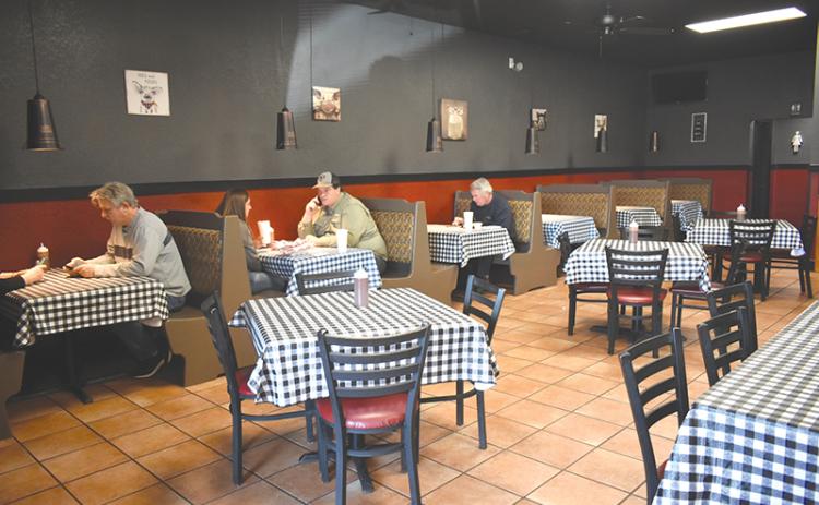 Customers enjoy a meal at Wolf Creek BBQ’s new location since a fire destroyed its former building in Cornelia and forced it to close for four months.