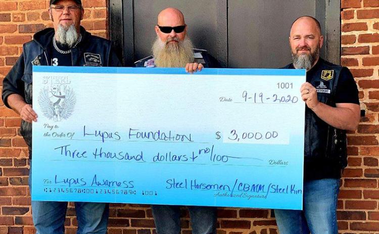 Chad Stinchcomb from Steel Horseman M/C of Athens, Amos “Moose” Smith from Steel Kin and Johnny Johnson from Cross Bearers MM of Habersham take a photo with a $3,000 check they helped raise for the Lupus Foundation in 2020.