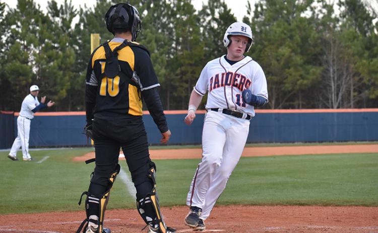 Habersham Central outfielder Austin Jones scores in the second inning on a sacrifice fly from Logan Bogue for one of the 16 runs the Raiders scored Monday night.