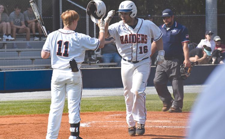 Logan Hare (16) high-fives teammate Austin Jones (11) following a solo home run in the first of two games Wednesday.