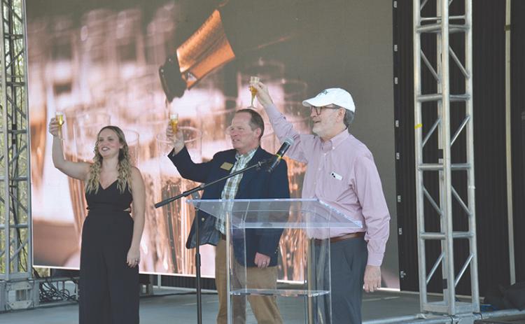 Piedmont University graduate Caitlin Fisher, Vice President for Marketing and Communications John  Roberts and President James Mellichamp toast the new christening of the school as a university Wednesday with sparkling apple juice.