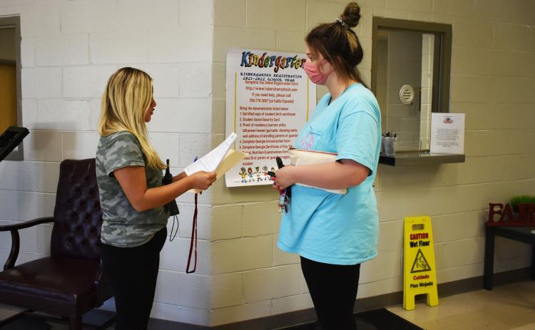 Karla Paramo, left, is the only Parent Involvement Coordinator at Level Grove Elementary School right now. On Tuesday, she met with parent Kayla Gerrells to go over some documents she needed to sign. CHAMIAN CRUZ/Staff