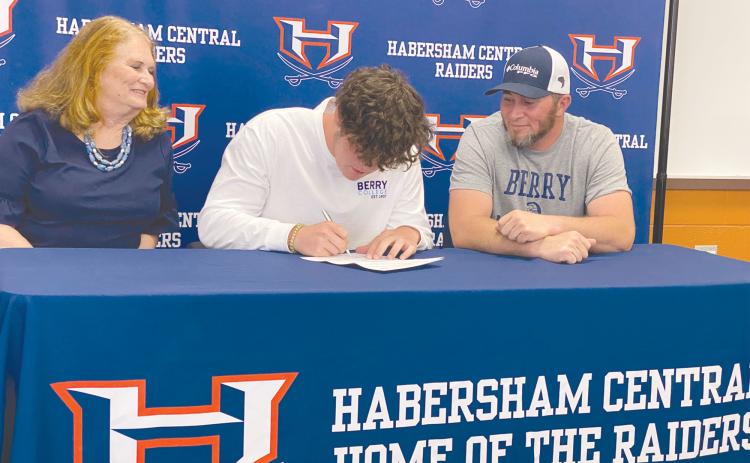 Parker Behrends (center) signs his national letter of intent April 29 to become the latest Raider to continue his track and field career at Berry College. With Behrends are his grandmother Mary Behrends and father Ray Behrends. ISAIAH SMITH/Staff