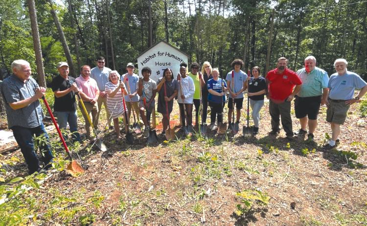 From left, Tom Gagnon, Ron Coker, Patrick Ledford, Kallan Williams, Nanette Baughman, Dan Nee, Enzo Combs, Tinisha Combs, Emyrie Combs, Lizzie Trimar, Marianne Longerbone and April Ferguson helped break ground for the Habitat for Humanity house in Demorest on Monday. BRIAN WELLMEIER/Staff