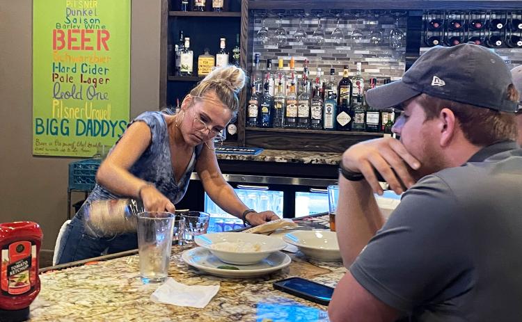 Bigg Daddy’s bartender Mary Childers serves patrons at the bar. While Bigg Daddy’s has a solid staff for now, other local restaurants are still seeking more staff as the pandemic abates. BRIAN WELLMEIER/Staff