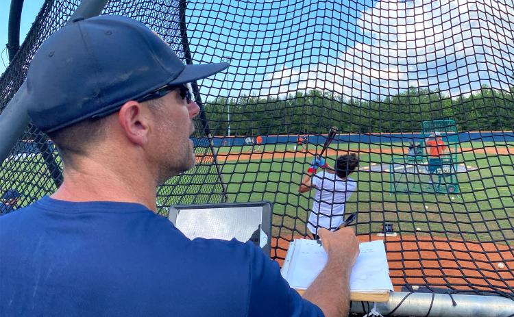Raiders head coach Chris Akridge watches a ball head toward the outfield before checking his iPad to record the ball’s exit velocity and launch angle. Using Rapsodo, these measurements and more can be seen as they happen by players and coaches. ISAIAH SMITH/Staff