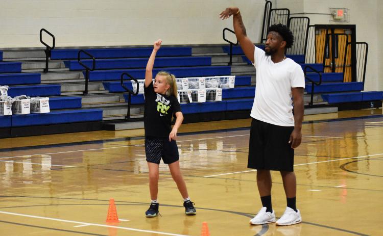 Shamir Dooley goes through a workout with Teagen Hicks. Dooley conducts individual workouts most days each week, along with coaching a travel team in his down time. ISAIAH SMITH/Staff