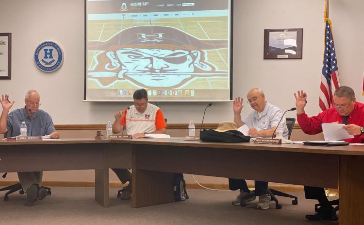 School board member Joey Duncan, chairperson Russ Nelson, board member Robert Barron and vice chairperson Doug Westmoreland vote on the rollback millage rate Monday. Not pictured is board member Kristie Dover. CHAMIAN CRUZ/Staff