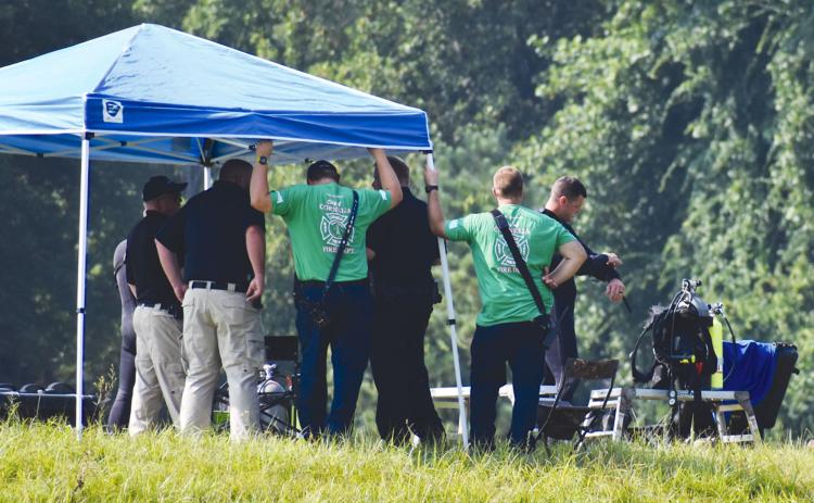 A diver from the Georgia State Patrol puts on his underwater gear shortly before first responders found the body of Mark Hicks on Monday morning. MATTHEW OSBORNE/Staff