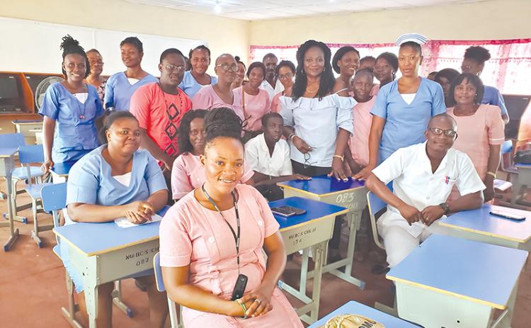 Dr. Marcella Davies (middle back with bracelet) stands with her students in Sierra Leone.