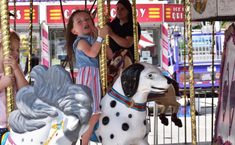 Hallie Hatchett and Oaklynn Edge enjoy the merry-go-round on Saturday afternoon at the Chattahoochee Mountain Fair. MATTHEW OSBORNE/Staff