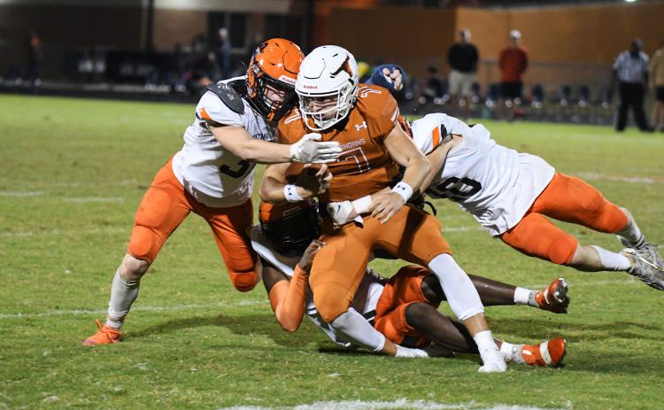Habersham Central’s Braydon Wright (left) and Noah Wilson lead a pile of Raiders tackling  Lanier quarterback Carson  Thomas during Friday’s game in Sugar Hill. TOM ASKEW/Special