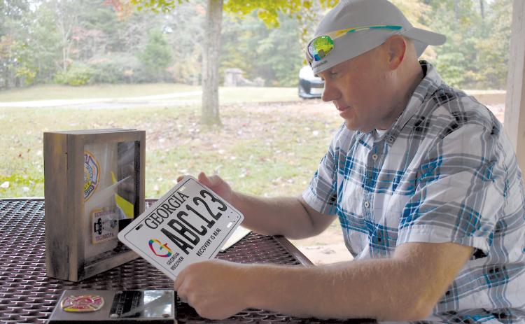 Jeremy Mitchell reflects on his time spent as a firefighter before running afoul of drugs and getting off track. The license plate was given for successful completion of drug court. MATTHEW OSBORNE/Staff