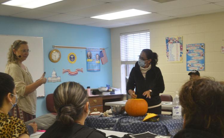 North Georgia Technical College’s ESL Director Michelle Wilson invites English learners to carve a pumpkin at First Baptist Church in Cornelia. BRIAN WELLMEIER/Staff