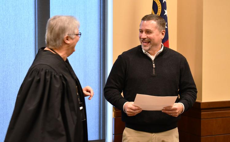 Commissioner Ty Akins and Judge Pam Wooley share a laugh after Akins was sworn in officially Wednesday by virtue of winning a special election Nov. 30. MATTHEW OSBORNE/Staff