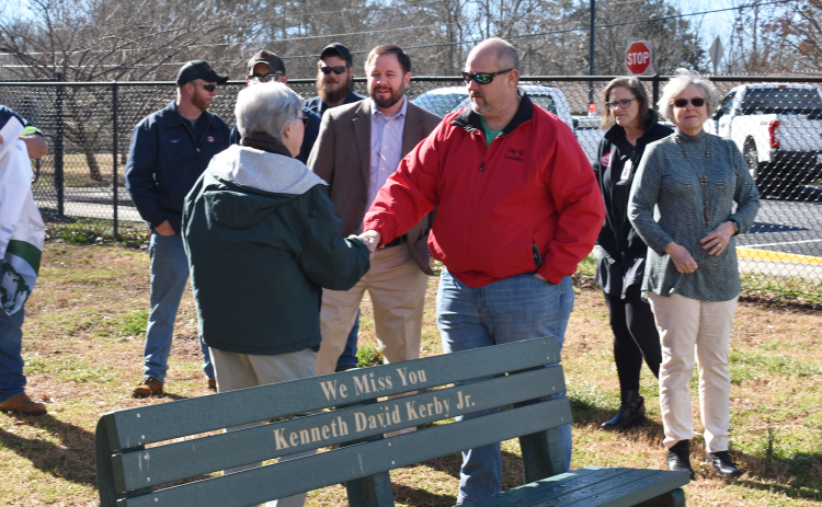 City Manager Donald Anderson, shown shaking hands with Susan Russell, and others celebrate the planting of a new Dogwood tree and commemorate longtime resident and frequent park attendee Kenneth David Kerby Jr., who passed away last year. AMARIS E. RODRIGUEZ/Staff