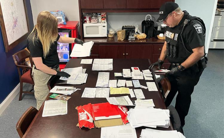 Habersham County Sheriff’s Crime Scene Technician Kayla Neal (left) and Demorest Officer James Minutello look over stolen mail seized after the arrest of Dylan Shope on Thursday. HABERSHAM COUNTY SHERIFF’S OFFICE/Submitted