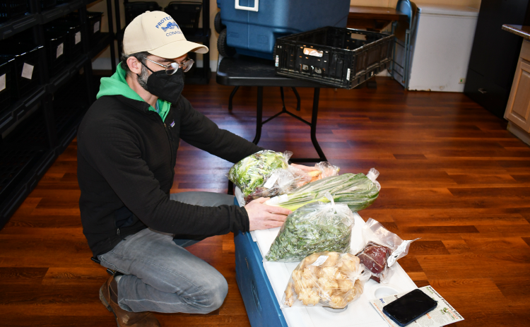 Andrew Linker handles fresh produce at Locally Grown’s Clarkesville location. BRIAN WELLMEIER/Staff