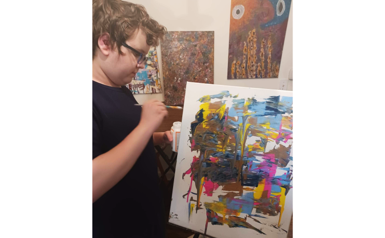 Joey Ray works on a recent rendering, the latest piece in his extensive collection of abstract paintings. SAMANTHA RAY/Submitted