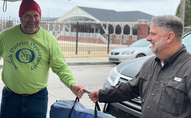 Mike Fisher accepts donations of tents and sleeping bags from Jamey Prickett of Gainesville First United Methodist Church. LARA MOORE/Submitted