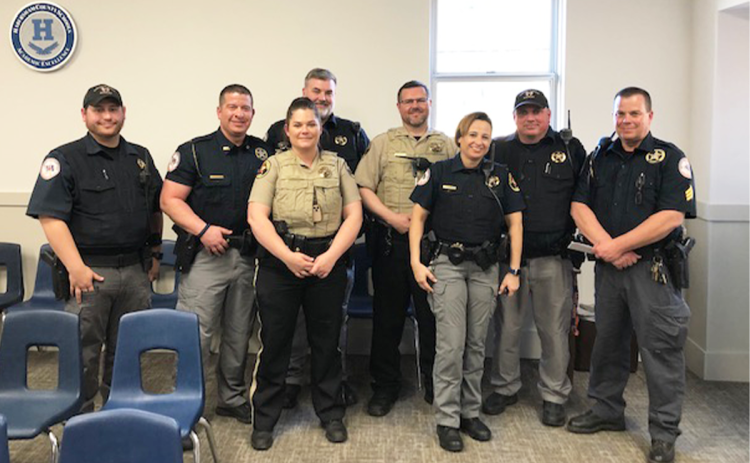 Habersham School Resources Officers (from left) Deputies Austin Martin, Wesley Littlejohn, Brittany Hallman, Paul Kent, Paul Harris, Evaleese Gonzalez, David Jackels and Sgt. Griggs Wall, along with Chief Deputy Murray Kogod (back), gather at Monday’s School Board meeting. AMARIS E. RODRIGUEZ/Staff