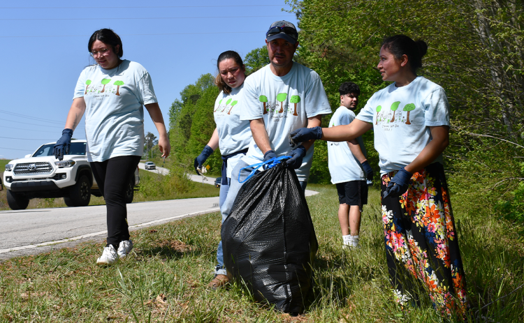 Baldwin residents collect trash from the roadside on Clean Up Day Saturday. BRIAN WELLMEIER/Staff